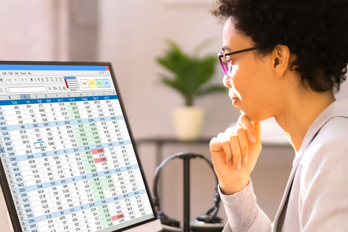 Analyst studying a spreadsheet of data on a monitor